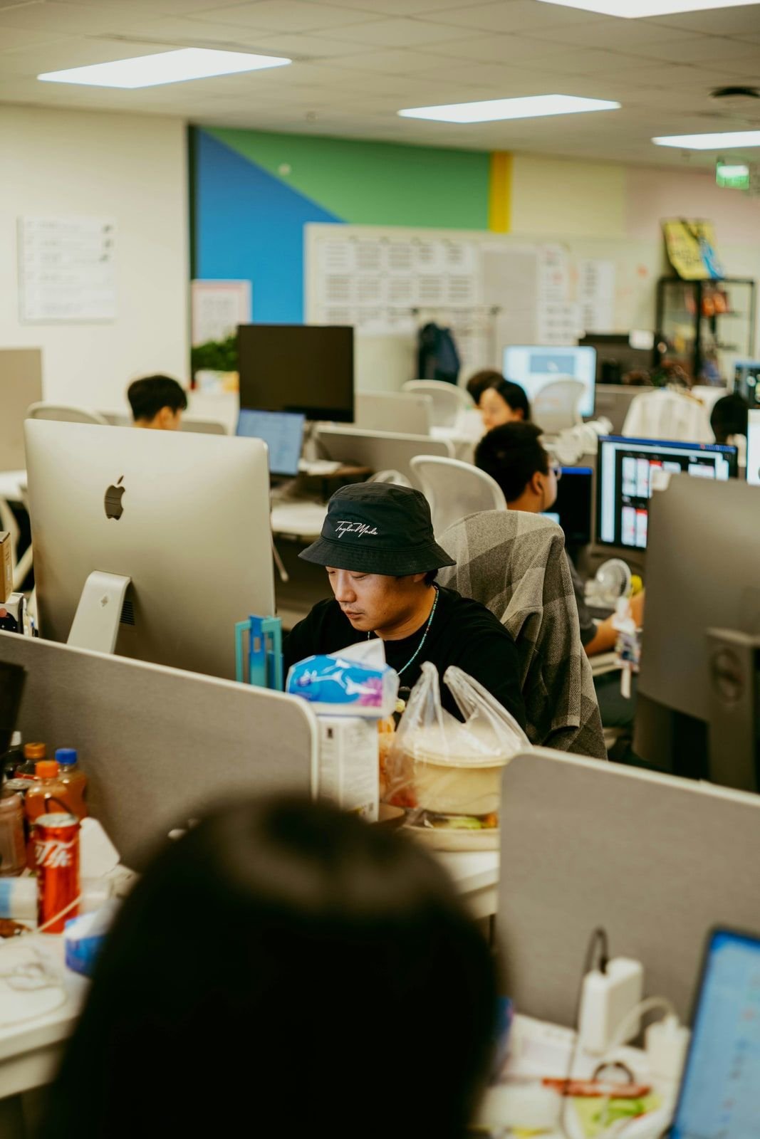 Office desks with monitors, takeout, and drinks during a workday
